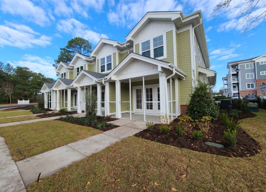 a large yellow house with a sidewalk in front of it  at Barclay Place Apartments, Wilmington, NC, 28412