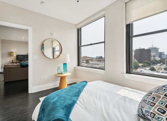 a bedroom with a bed and three windows