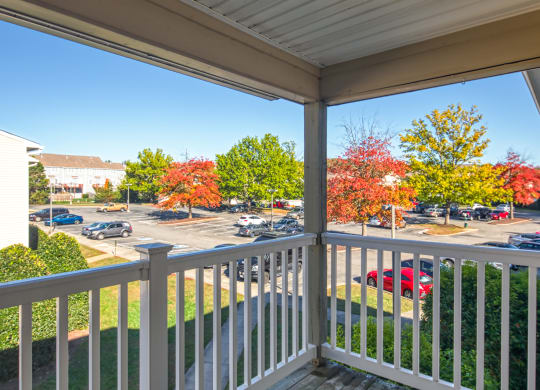 the view from the balcony of a building with cars in a parking lot