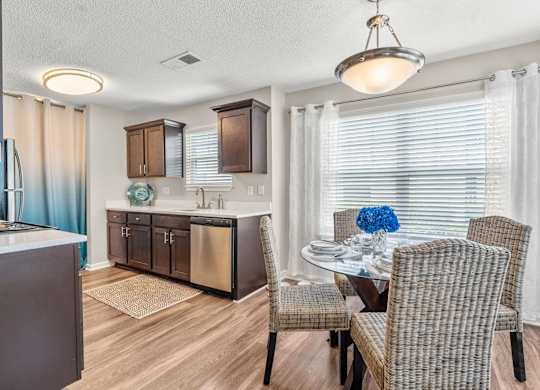 A modern kitchen with a dining table set for two.