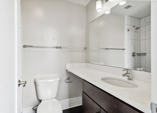 a bathroom with a toilet sink and mirror