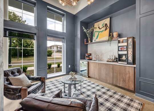 A grey living room with a black and white checkered rug.