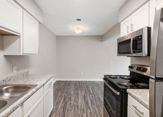 a kitchen with white cabinets and a black stove top oven