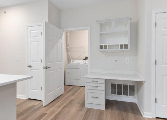 a kitchen with white cabinets and white appliances and a white desk at The Charleston, Columbus, 43221