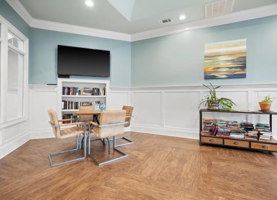a dining room with a table and chairs and a tv on the wall
