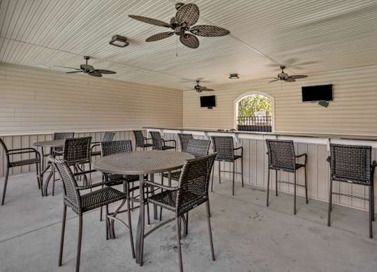A patio with a table and chairs and a ceiling fan.