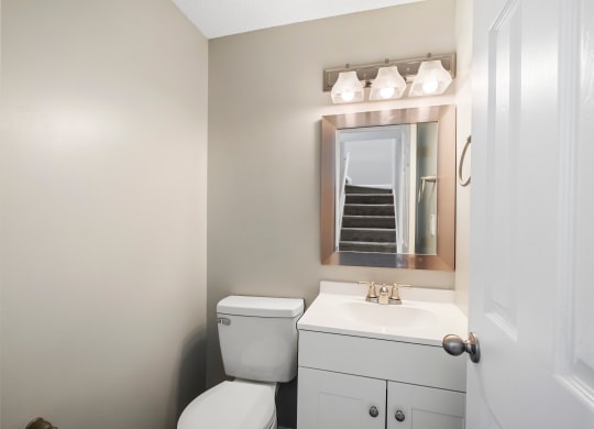 a bathroom with a toilet sink and mirror