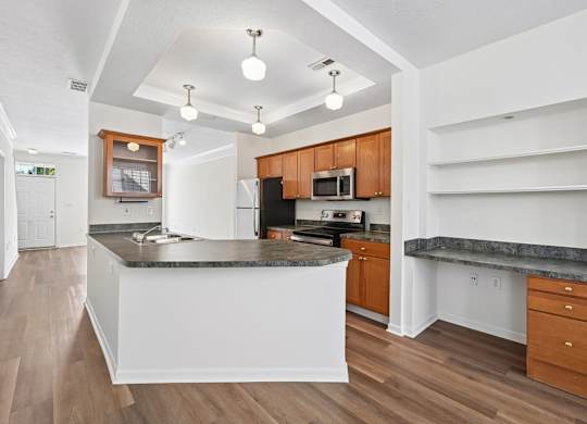 A kitchen with a white island and wooden cabinets.