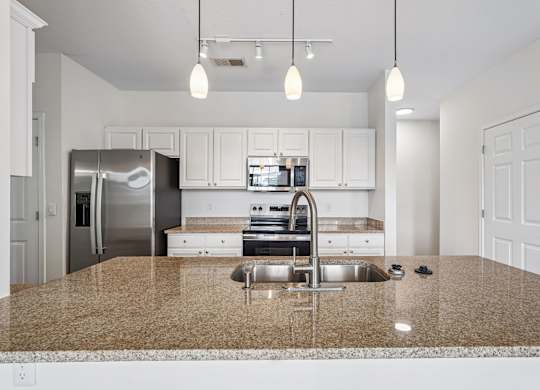 A kitchen with granite countertops and stainless steel appliances.