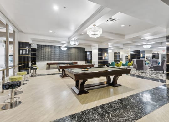 a spacious game room with two pool tables and a bar