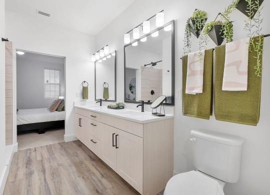 a bathroom with white walls and wood flooring
