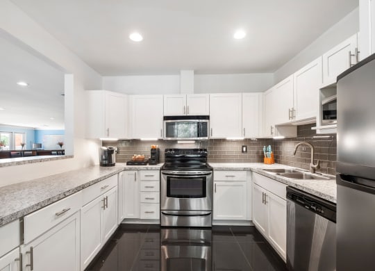 a kitchen with white cabinets and black appliances