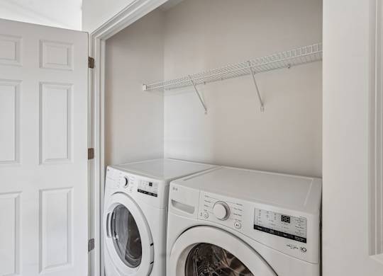 Two white washing machines in a laundry room.