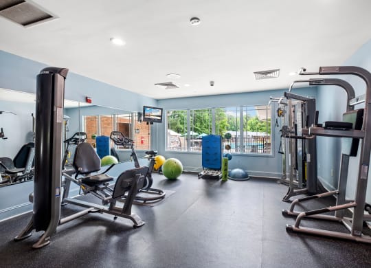 a gym with exercise equipment and a large window