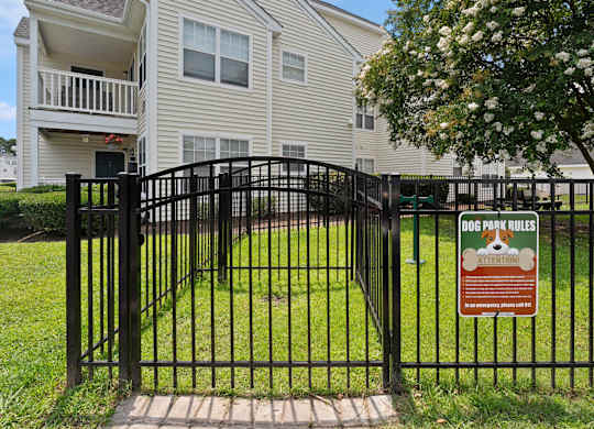 A sign on a gate that says Dog Park Rules.