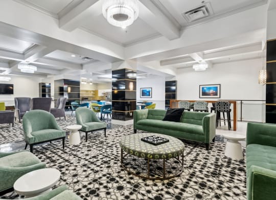 a lobby with green couches and chairs and a black and white checkered floor
