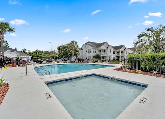 A swimming pool in a residential area with houses in the background.