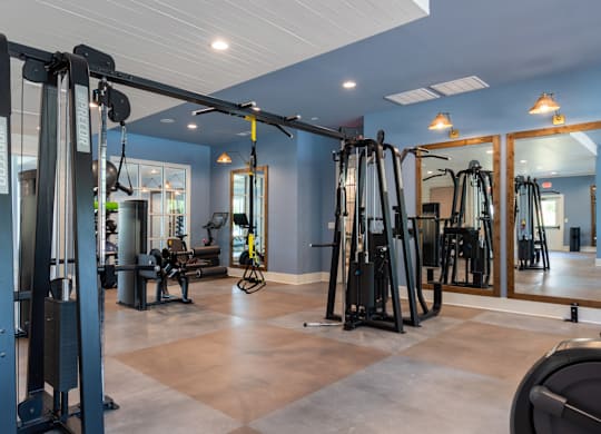 A gym with a variety of equipment including treadmills, weights, and exercise machines.