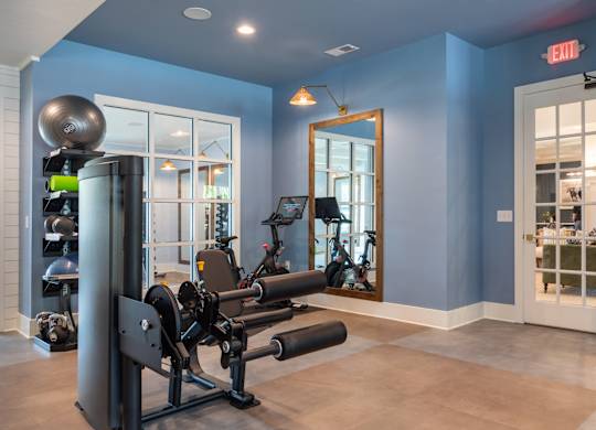 A gym with a weightlifting bar and a mirror.
