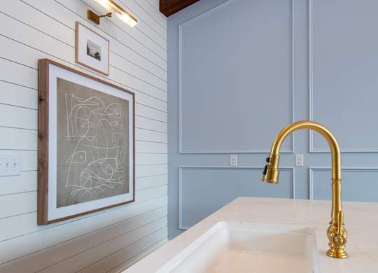 A bathroom with a sink and a framed drawing on the wall.