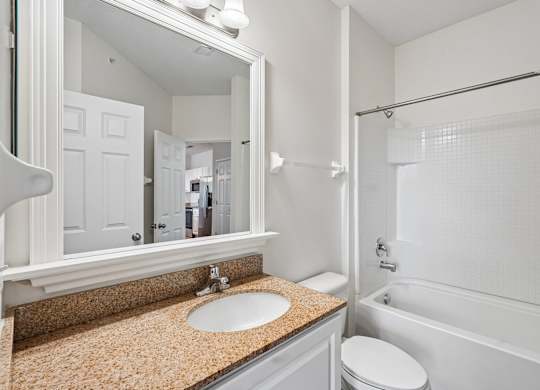 A bathroom with a sink, toilet, and bathtub.