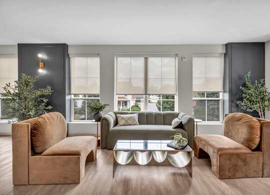 A living room with brown and grey furniture and a large window.