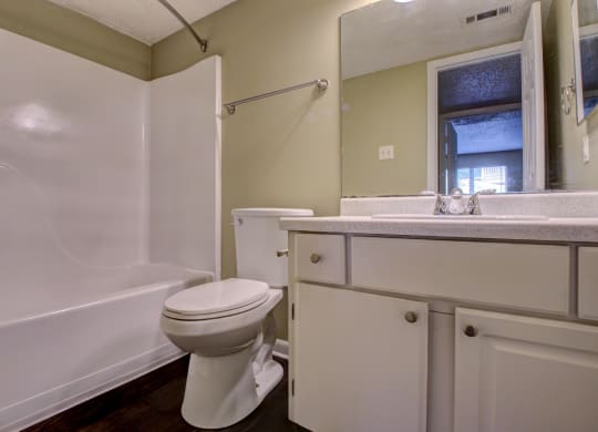 a bathroom with a toilet and a tub and a sink