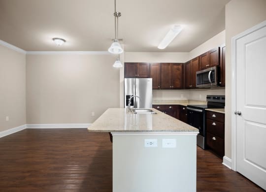 an empty kitchen with a marble counter top and