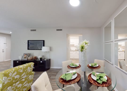 a living room with white walls and a glass table with three plates of food on it
