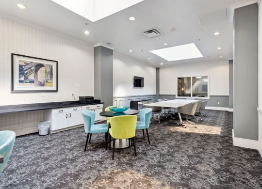 a common area with a table and chairs and a kitchenette