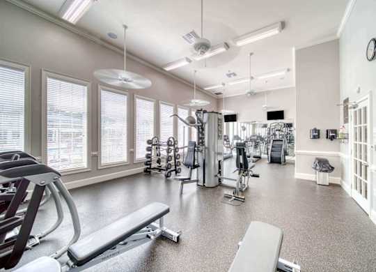 A spacious gym with a variety of equipment including treadmills, weights, and exercise machines.