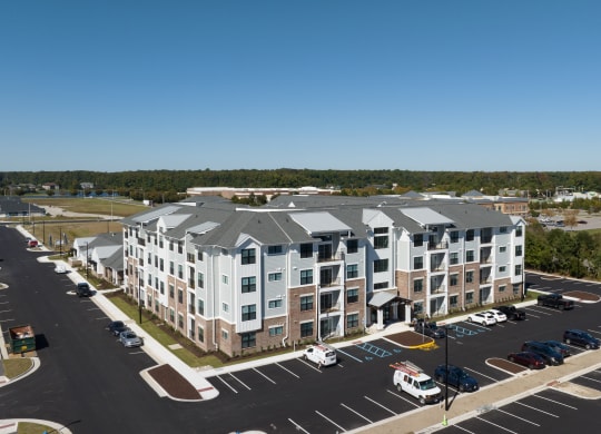 an aerial view of an apartment building with a parking lot