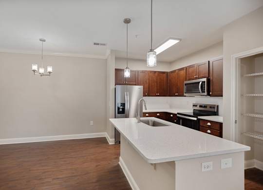 A kitchen with white countertops and wooden cabinets.