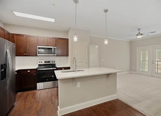 A kitchen with a refrigerator, oven, and microwave.