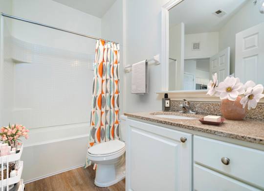 A white bathroom with a toilet, sink, and shower.at Arlington Park, Hilliard, OH
