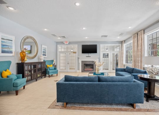 a living room with blue couches and chairs and a fireplace