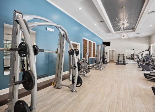 a gym with weights and other exercise equipment and a light blue wall