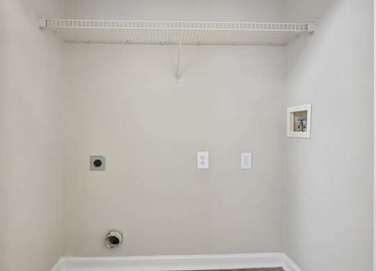 A white bathroom with a white tub and a white towel rack.