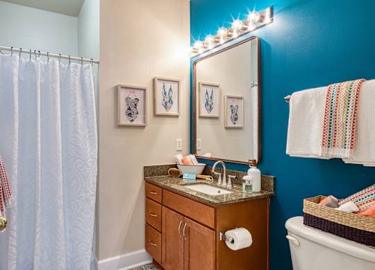A bathroom with a blue wall and a white towel hanging on the towel rack.