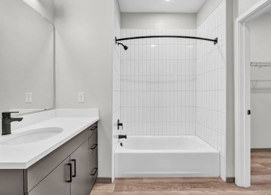 A white bathroom with a white tub and a white sink.