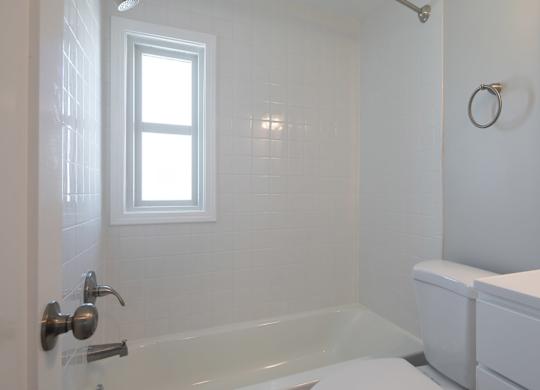 A white bathroom with a tub, toilet, and sink.