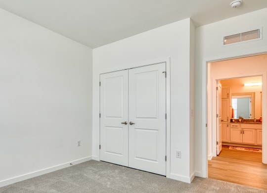 a bedroom with white doors and a door to a bathroom at Allure at Edinburgh, Chesapeake, VA
