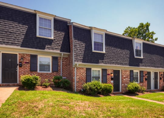 a brick apartment building with a sidewalk in front of it