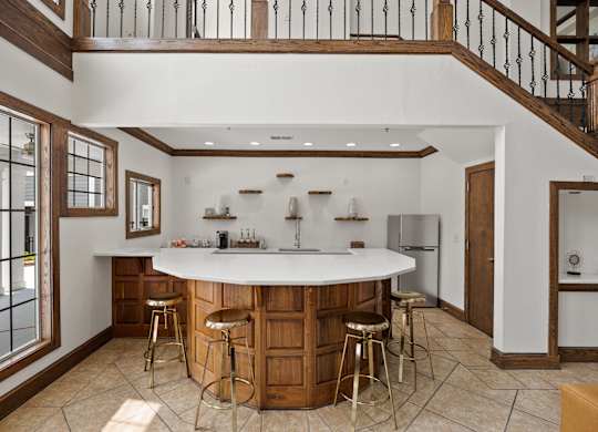 A kitchen with a bar and stools.
