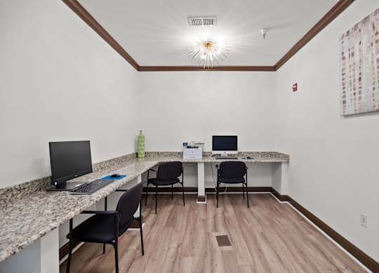 A room with a desk and chairs.
