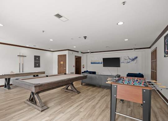 A room with a foosball table and air hockey table.