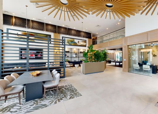 the lobby of a hotel with a reception area and a large plant