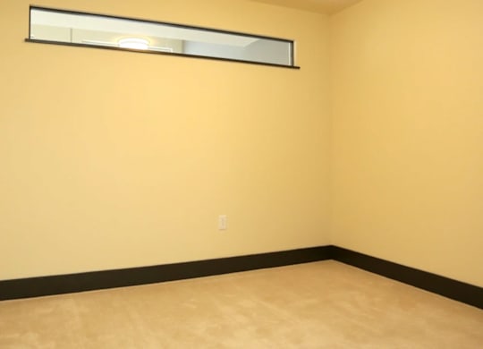 A room with a yellow wall and a window.