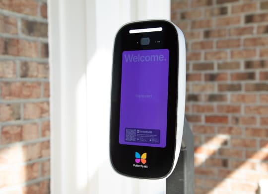 a iphone sitting on a pole in front of a brick wall