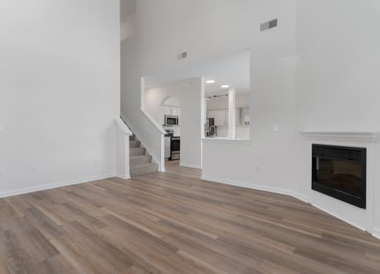 a living room with white walls and a fireplace and wooden floors at The Charleston, Ohio